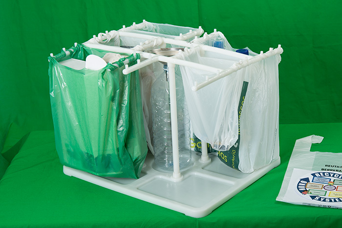 Cubo de basura con bolsas de plástico para separar residuos y botella de plástico para reciclar el aceite usado